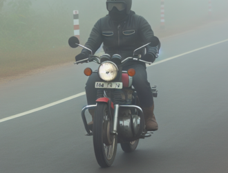 A motorcyclist riding through heavy fog