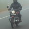 A motorcyclist riding through heavy fog